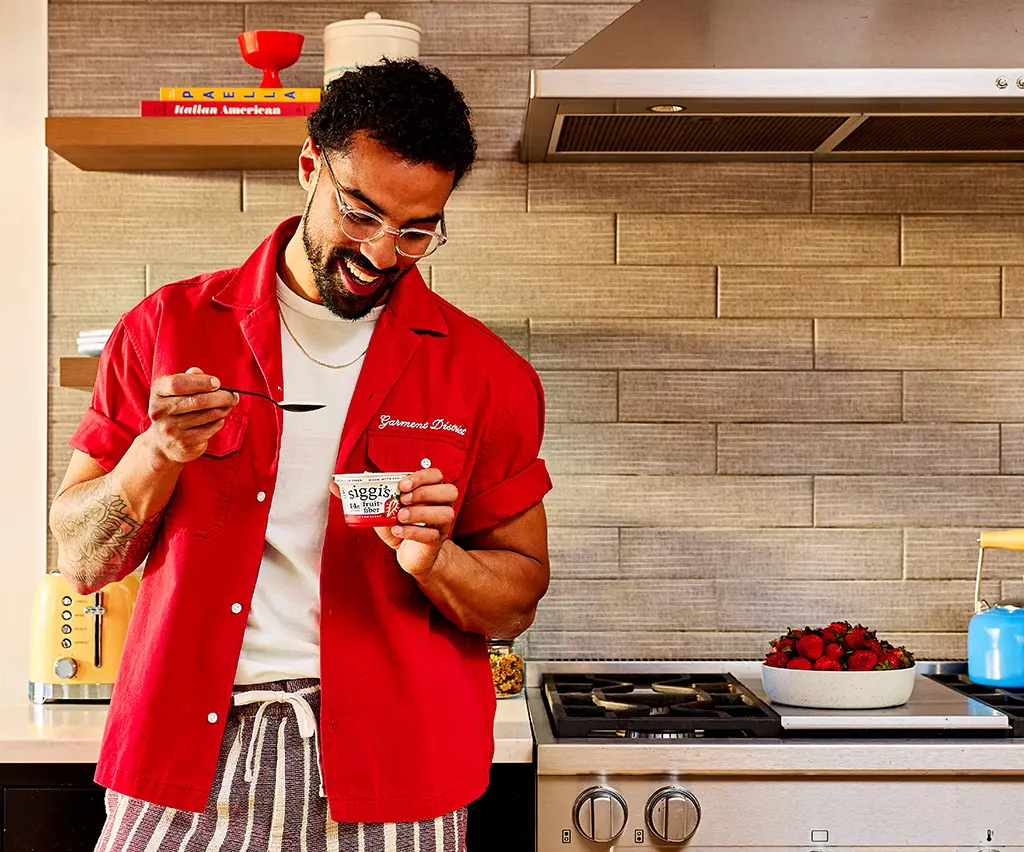 man eating siggi's fruit & fiber in a kitchen