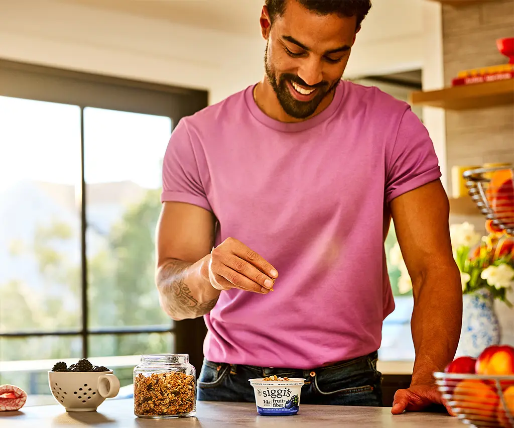 man in a kitchen with siggi's fruit and fiber blueberry blackberry