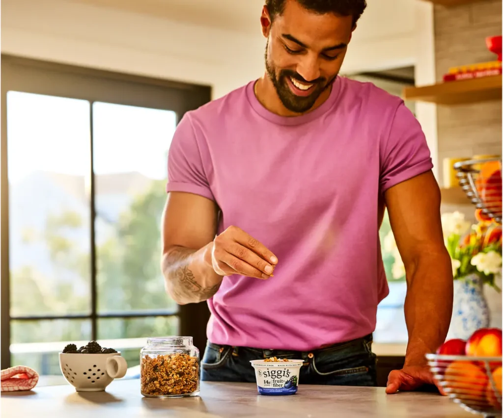 man in a kitchen with siggi's fruit and fiber blueberry blackberry