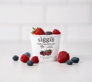 yogurt container with berries in and around it
